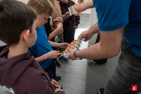 kids reaching for colorful sticker sheets