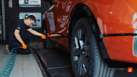 meccanico ispeziona ruota e pneumatico suv in officina