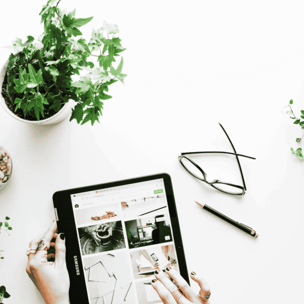 hands on tablet flatlay with indoor plants