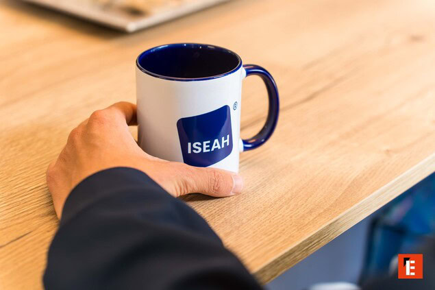 tasse bleue sur table en bois avec main