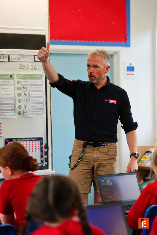 teacher giving thumbs up to students with laptops