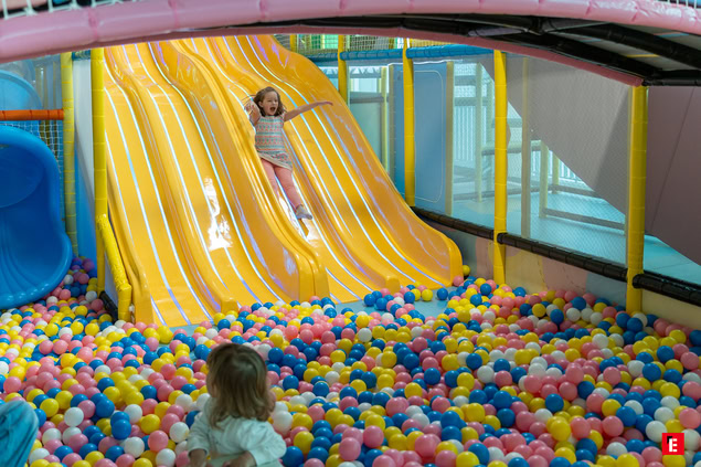 enfants au toboggan jaune et piscine à balles