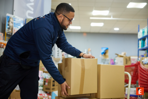 empleado de tienda reponiendo cajas en almacén