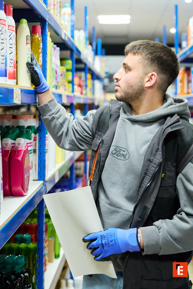 reponedor con guantes revisando inventario en almacén