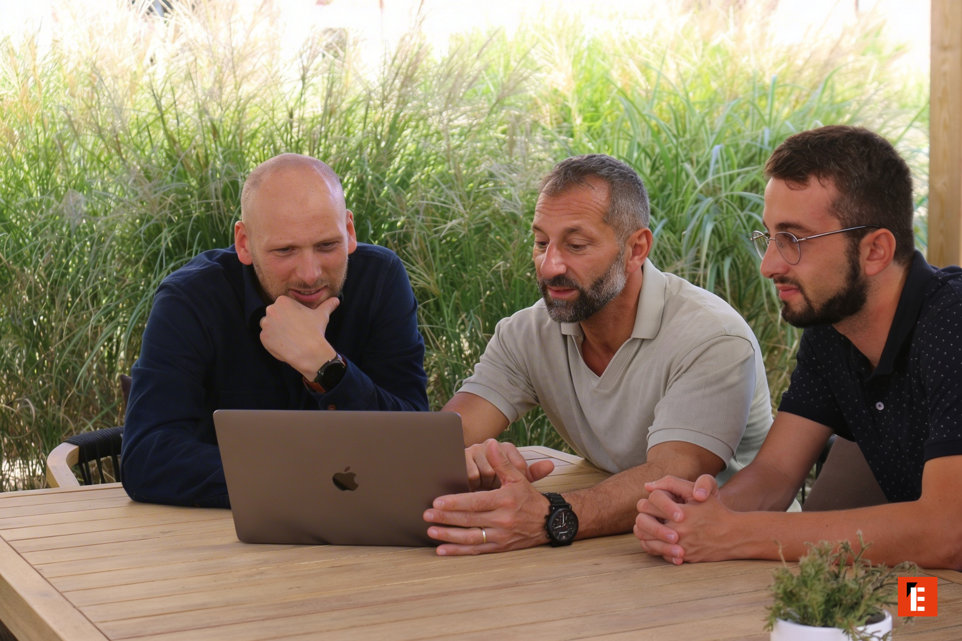 trois hommes en réunion autour dun portable
