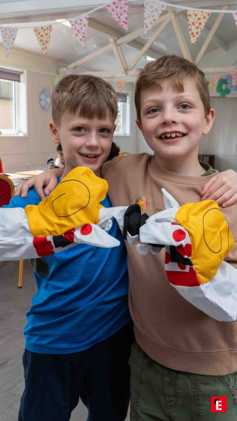 smiling boys with yellow puppets at party