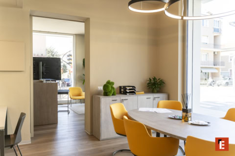 sala riunioni luminosa con tavolo ovale e sedie gialle