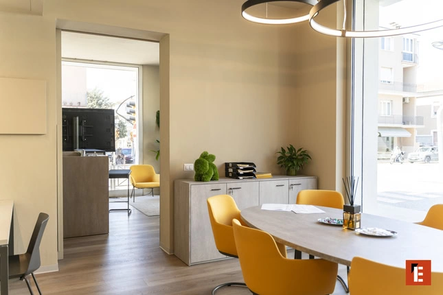 sala riunioni luminosa con tavolo ovale e sedie gialle