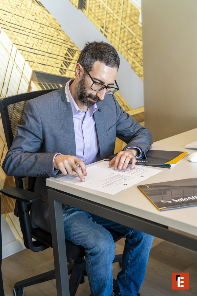 uomo rivede documenti su scrivania moderna