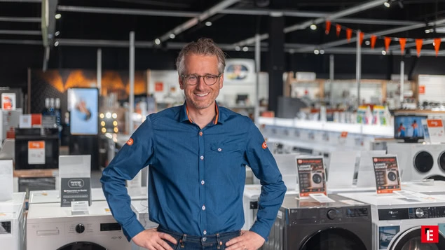 vendeur dÉlectroménager souriant devant rangée de lave linge