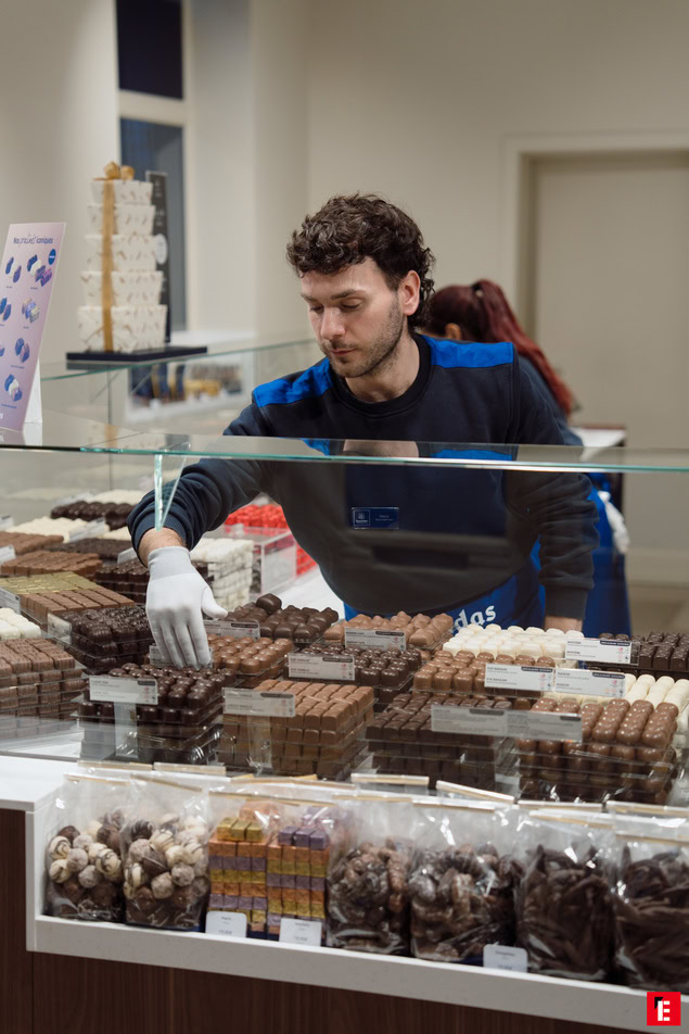 vetrina di cioccolatini artigianali e cioccolatiere con guanti