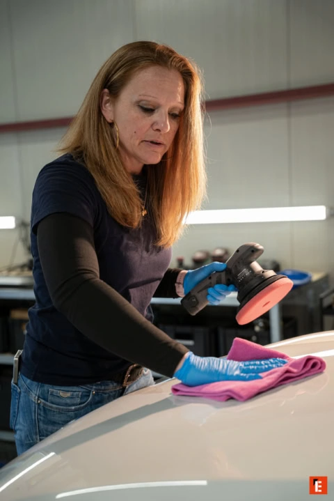 détail auto : femme polissant un capot