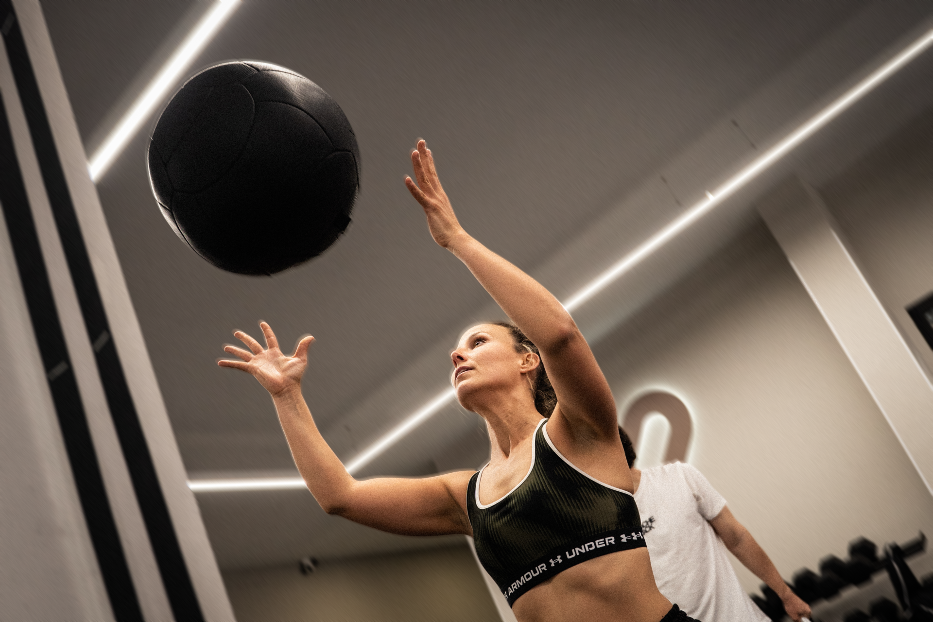 mujer fitness con balón medicinal en gimnasio