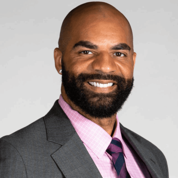 smiling bald professional headshot in suit and tie