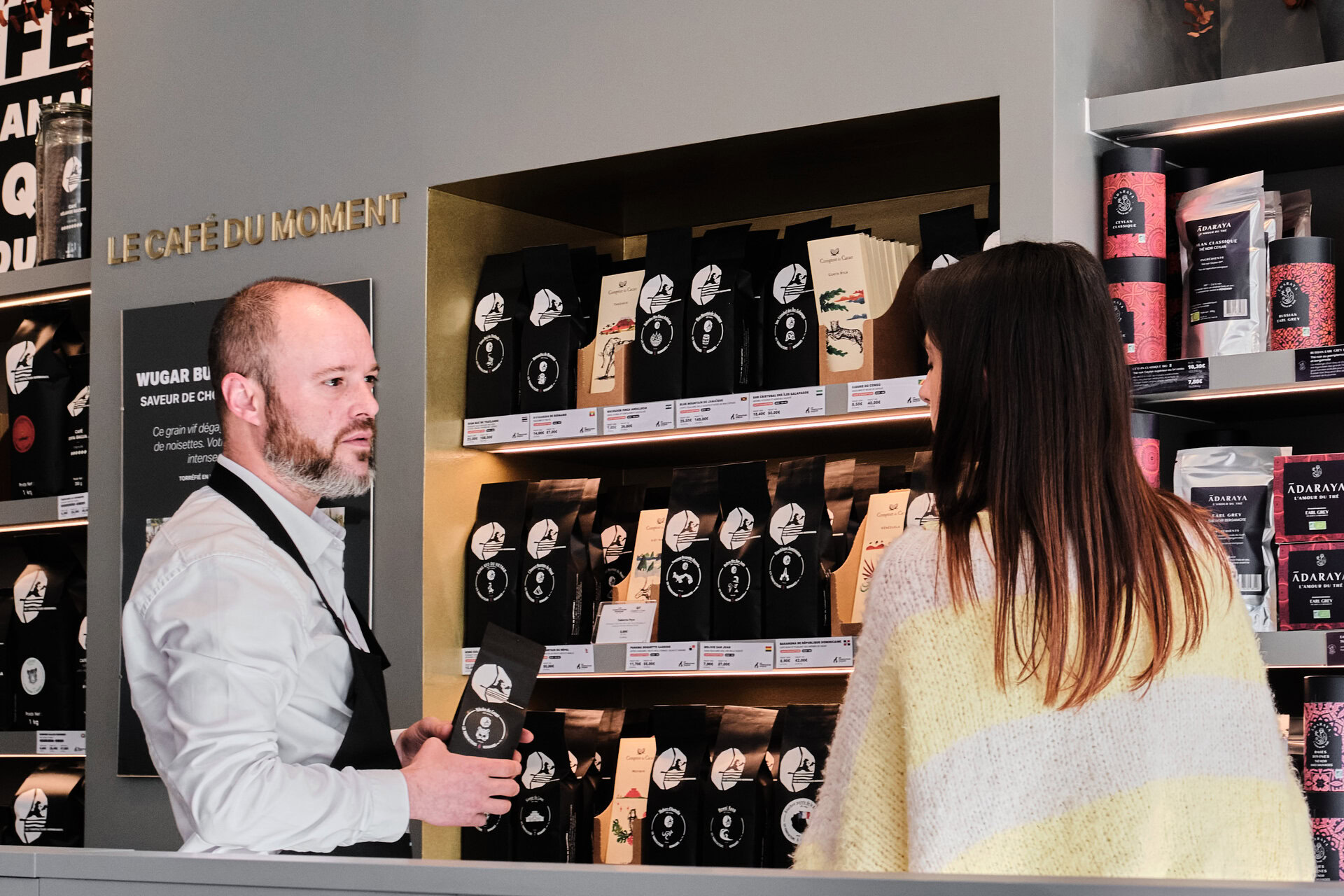 barista explique les cafés en boutique artisanale