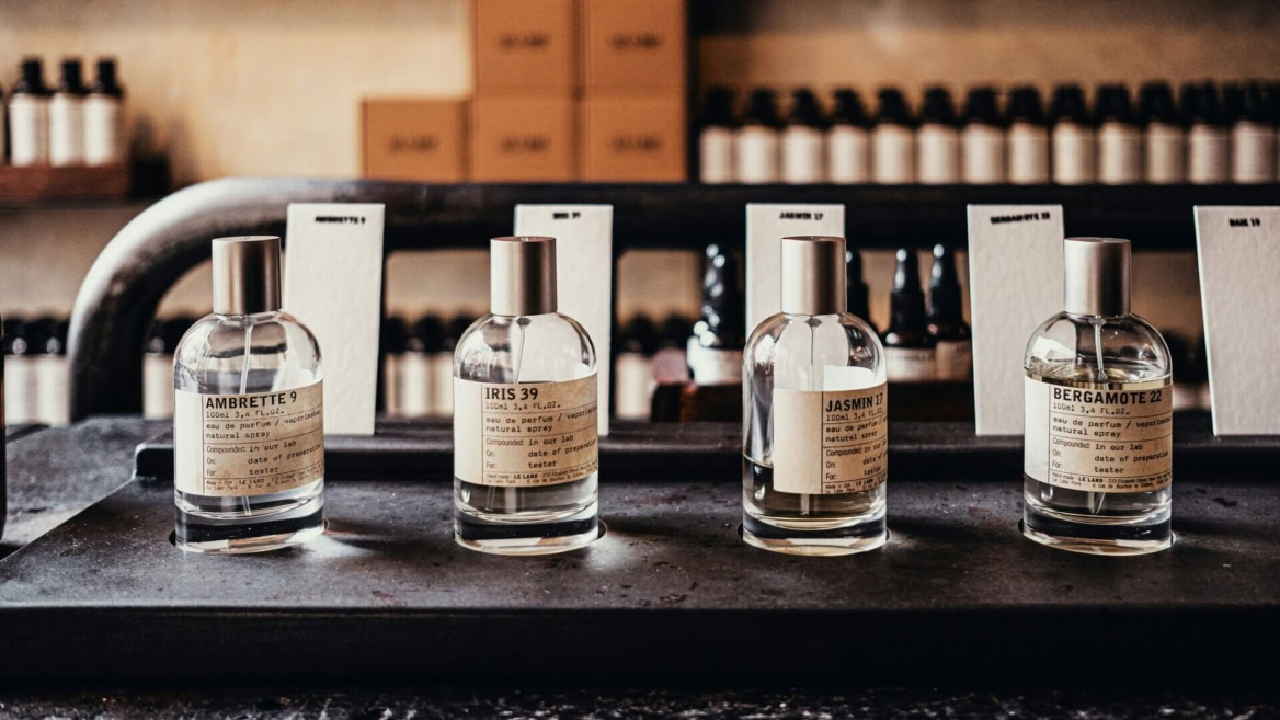 bottiglie di profumo artigianali minimaliste su ripiano vintage