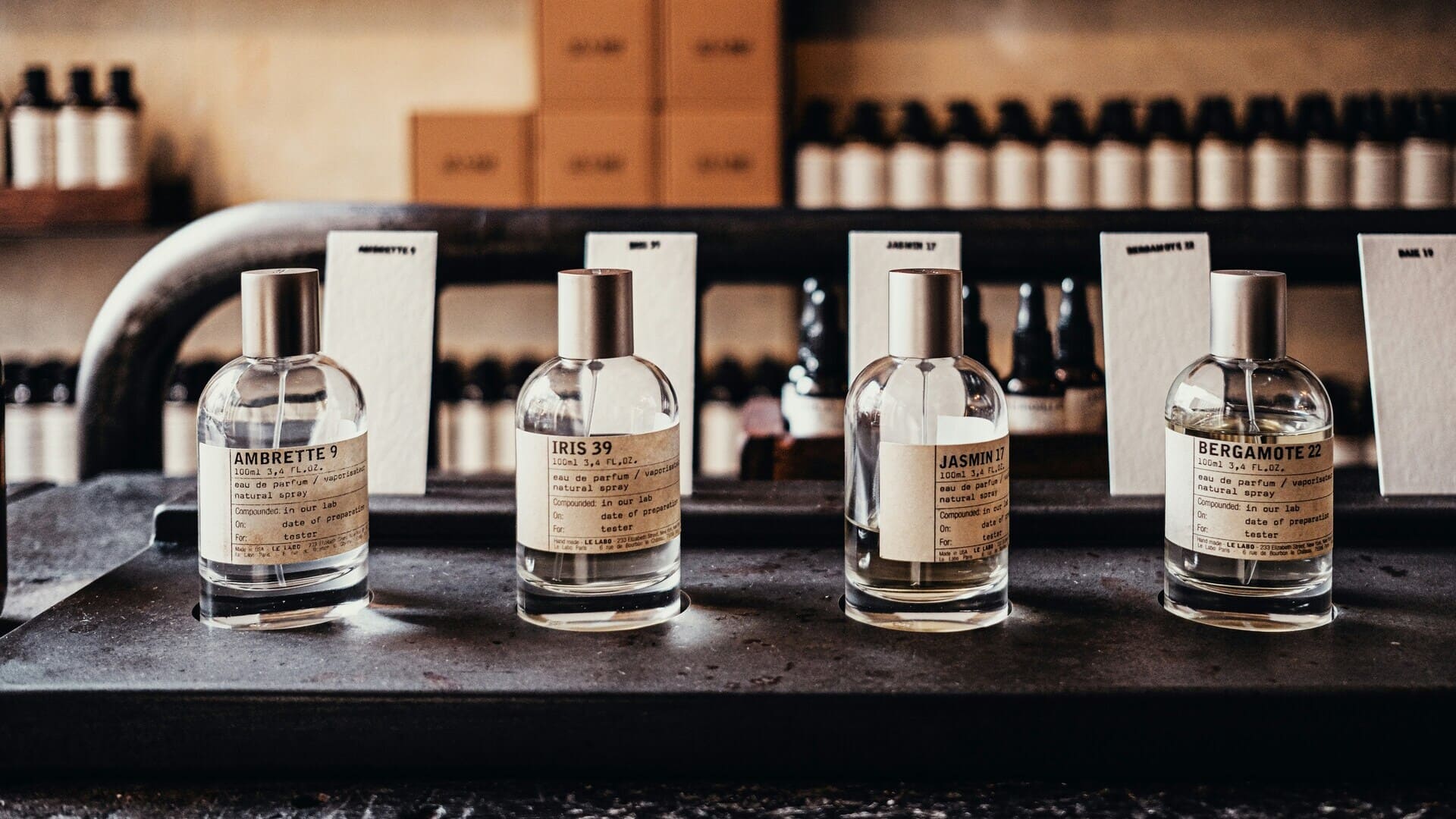 bottiglie di profumo artigianali minimaliste su ripiano vintage