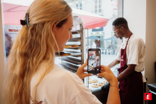 client photographiant une vitrine de pâtisseries lumineuse