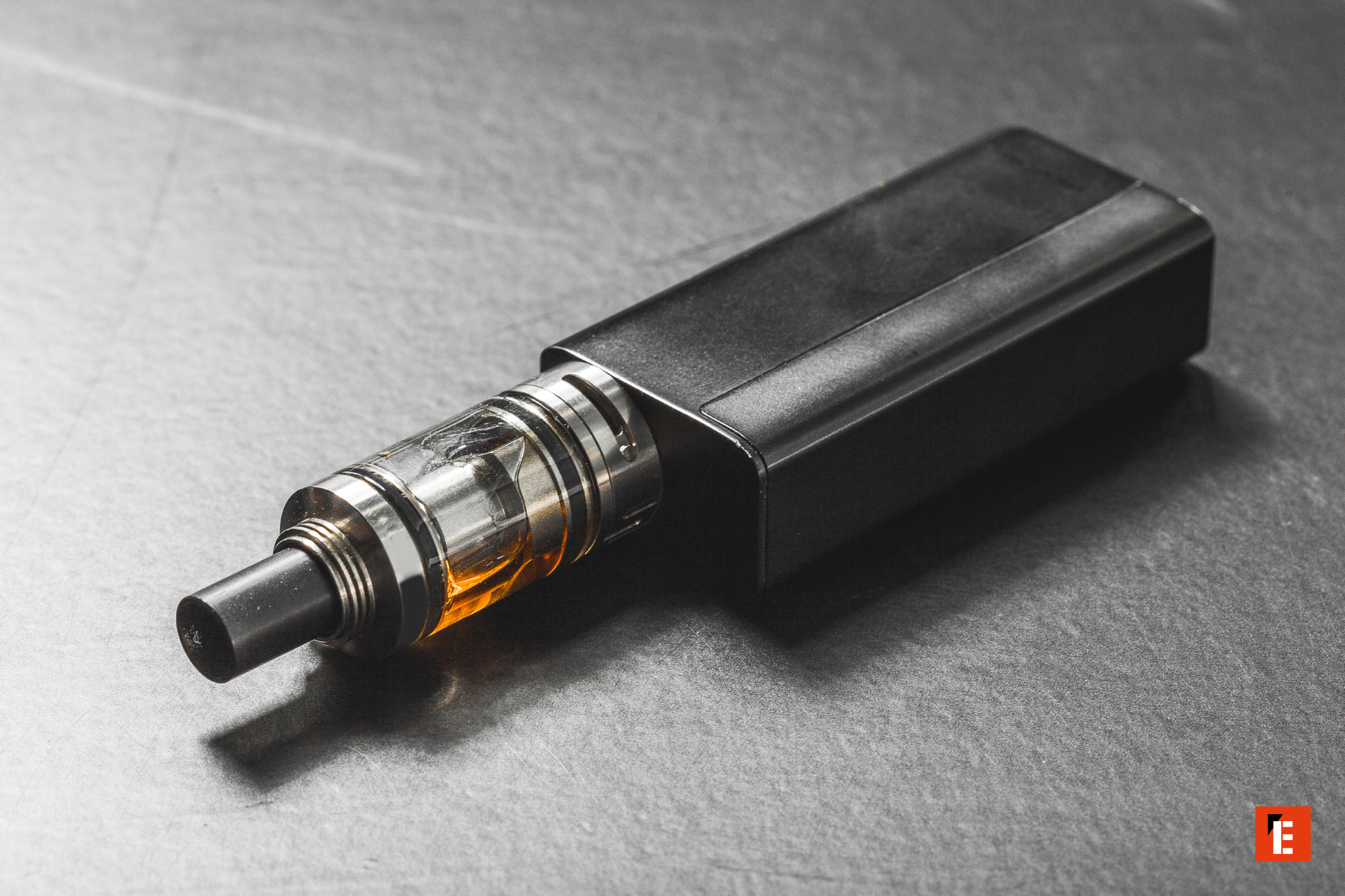 box mod et clearomiseur transparent avec e‑liquide ambré