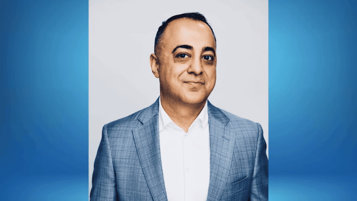 executive headshot: man in gray checked blazer