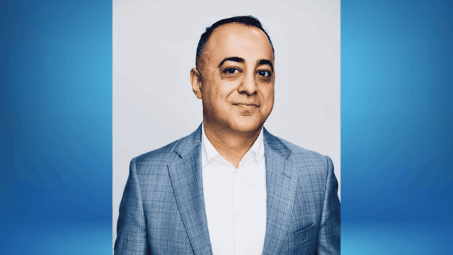 executive headshot: man in gray checked blazer