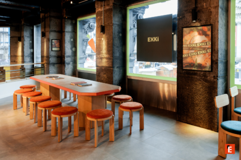 café communautaire moderne : table commune et tabourets orange