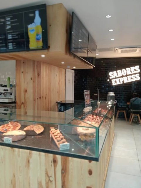 cafetería moderna con vitrina de pasteles y pizzas