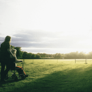 caregiver pushing wheelchair at golden hour
