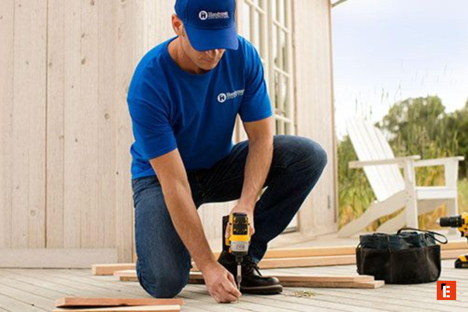 carpenter installing outdoor deck with cordless drill