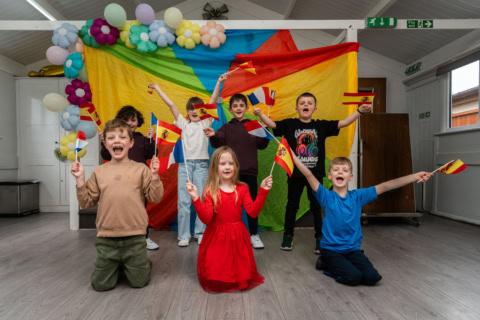schoolchildren cheering with french and spanish flags