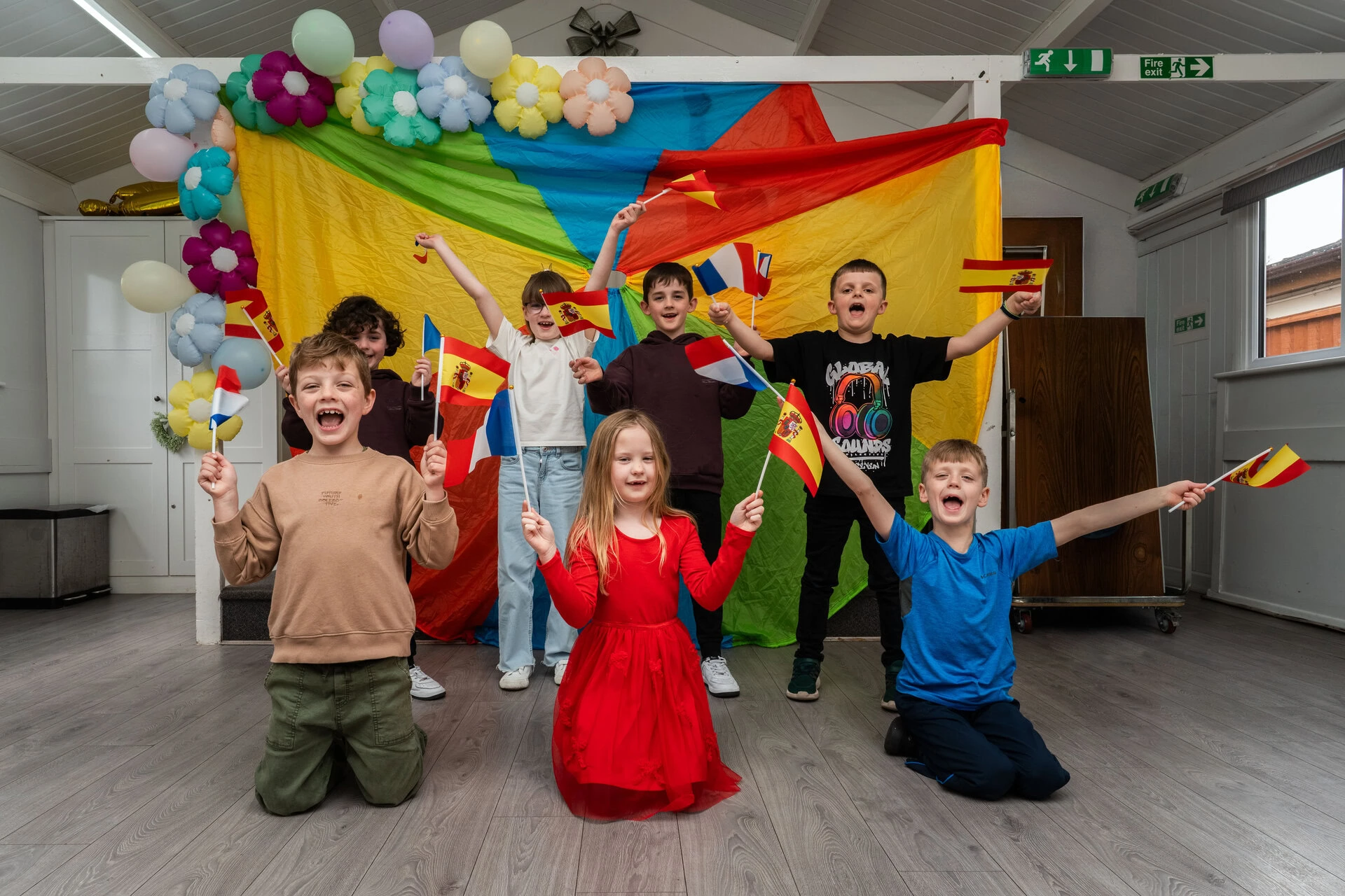 schoolchildren cheering with french and spanish flags