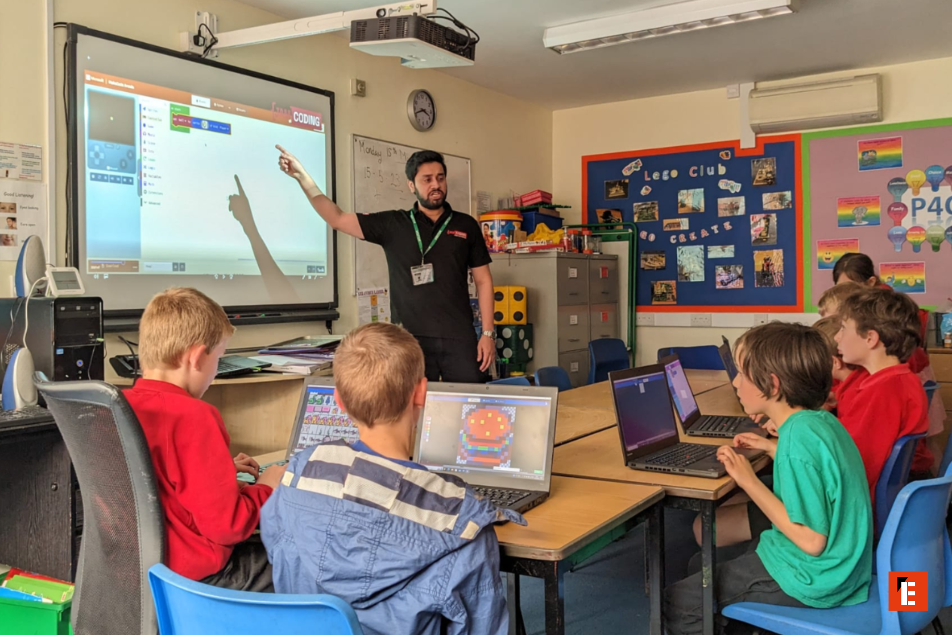 elementary students coding on laptops in classroom