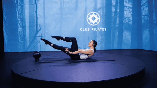 club pilates teaser pose in forest studio
