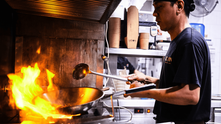 cocinero profesional domina el wok en llamas