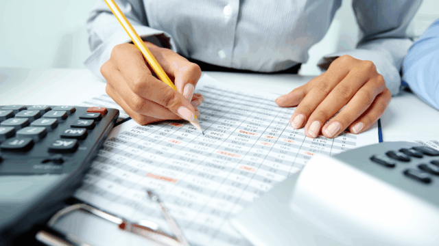 manos revisando hojas de cálculo y finanzas