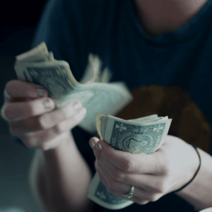 close up of hands counting us one dollar bills