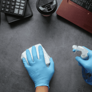 workspace desk cleaning with gloves and spray