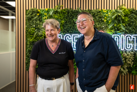 deux collègues souriants dans bureau végétal moderne