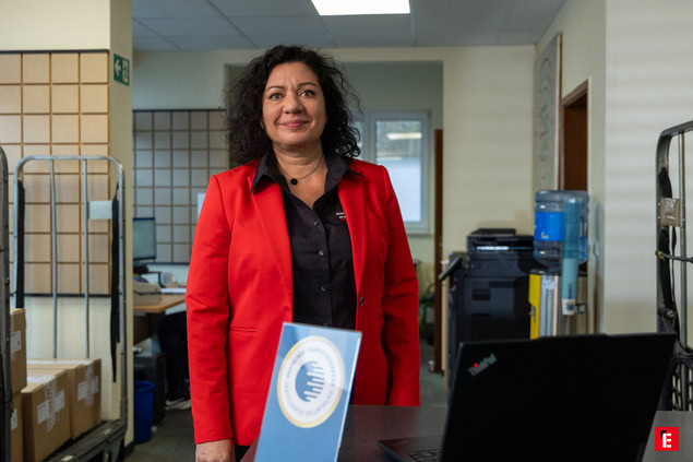 frau im roten blazer mit auszeichnung im büro