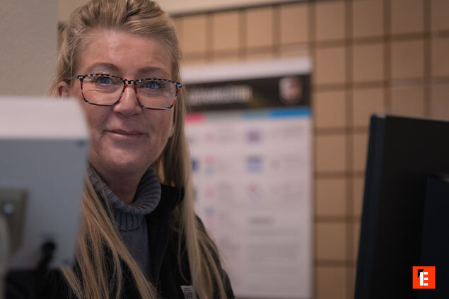 servicekraft am empfang mit brille im büro