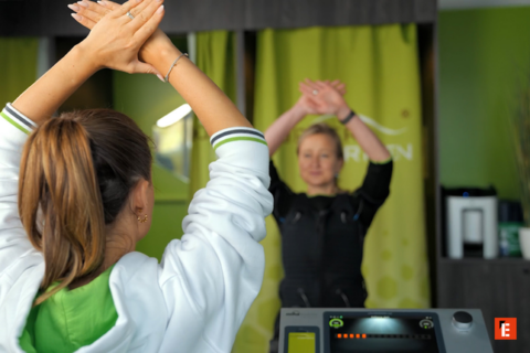 stretching im fitnessstudio: trainerin und teilnehmerin