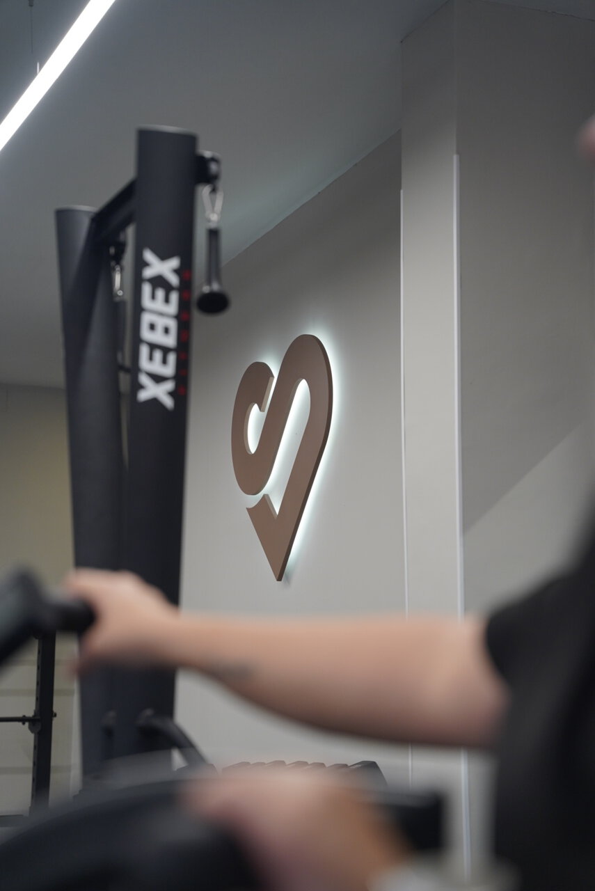 emblema corazón iluminado en gimnasio moderno