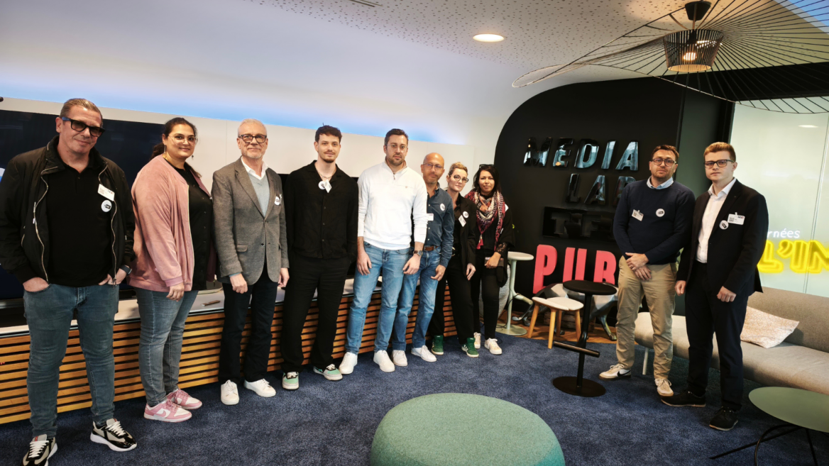 Équipe en visite dans un espace média moderne