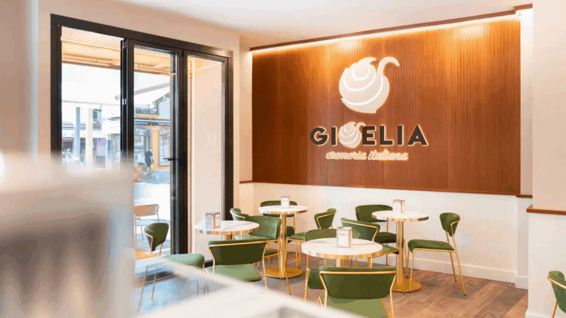 cafetería moderna con mesas de mármol y sillas verdes