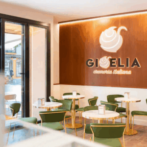 cafetería moderna con mesas de mármol y sillas verdes