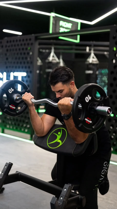 curl biceps au banc scott en salle de sport moderne