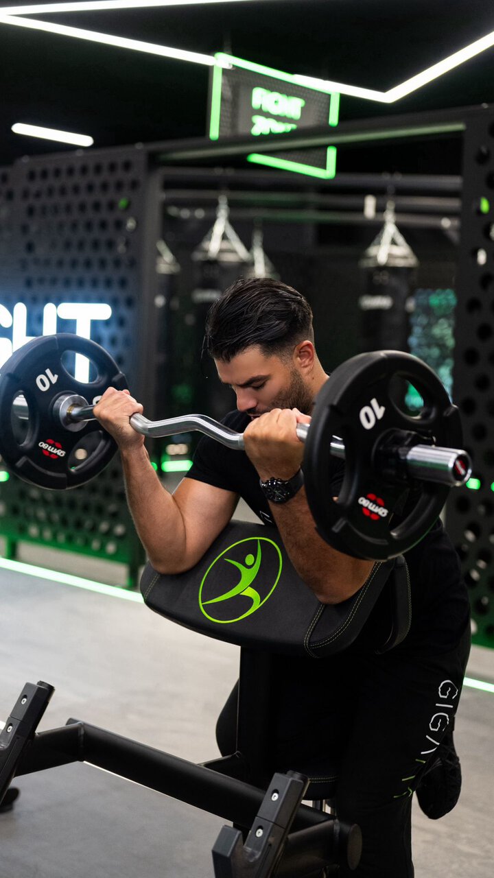 curl biceps au banc scott en salle de sport moderne