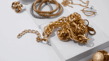 cadena dorada, pulseras y perla en fondo minimalista