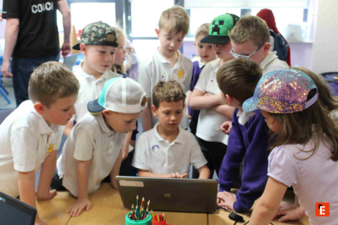 students gathered around laptop for group learning