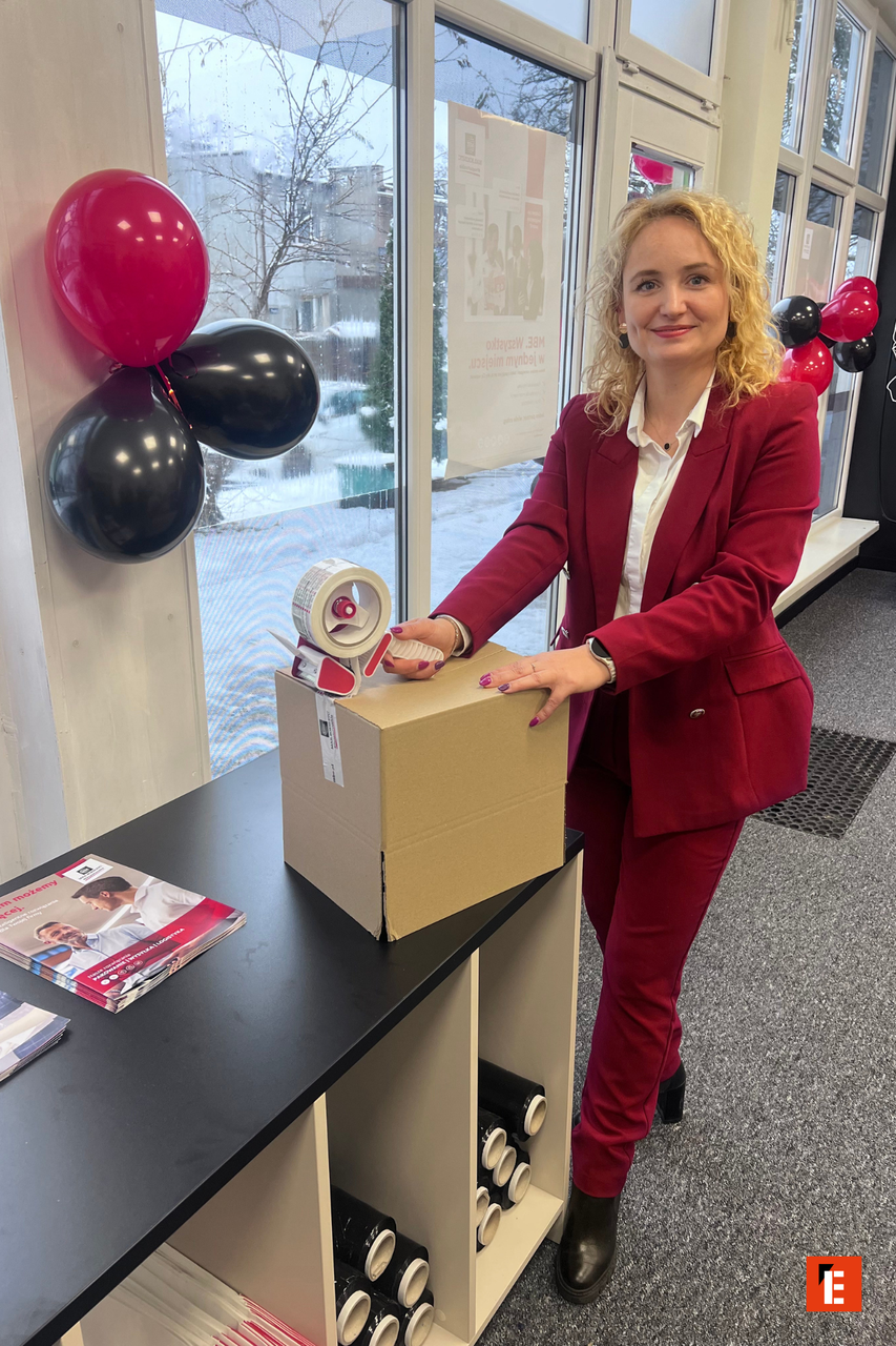 kobieta pakuje paczkę w biurze z balonami